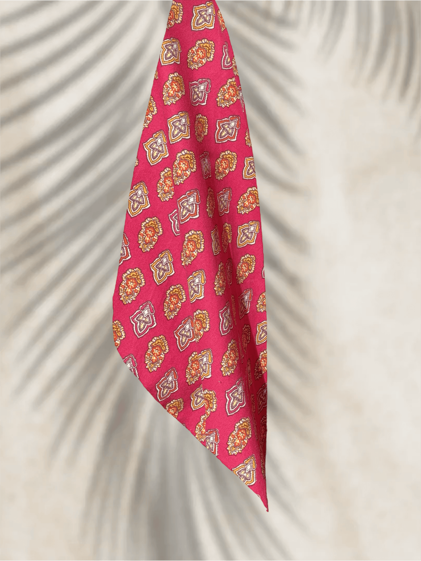Bandana fuchsia en coton Valdrôme avec motif indienne, photographié en lumière naturelle avec ombre de palmier en arrière‑plan.