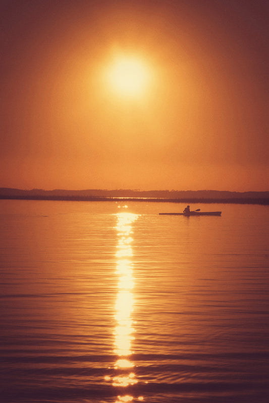Golden Path, photographie fine art d’un kayak au coucher de soleil avec reflet doré sur l’eau.