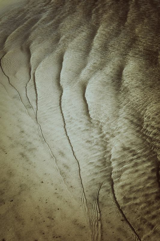 Photographie minimaliste de sable ondulé sous l’eau, texture naturelle du lac, œuvre Fine Art encadrée pour décoration intérieure.