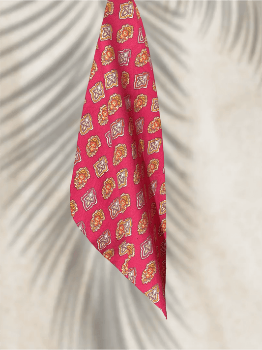 Bandana fuchsia en coton Valdrôme avec motif indienne, photographié en lumière naturelle avec ombre de palmier en arrière‑plan.