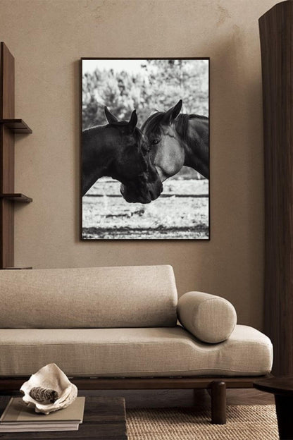 Tirage de chevaux en noir et blanc encadré, accroché dans un salon moderne beige avec canapé arrondi.