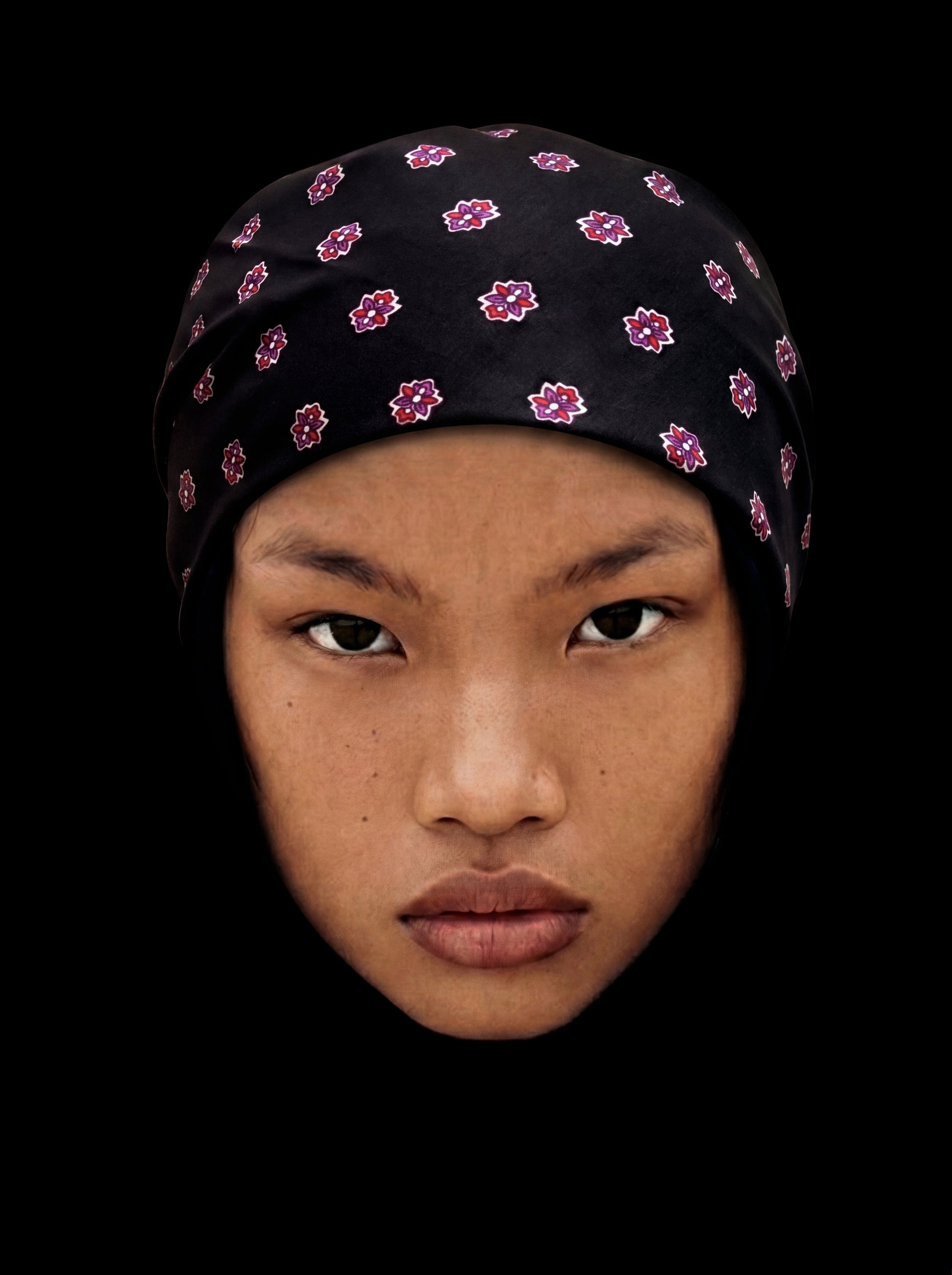 Bandana noire en coton avec médaillon, style élégant, portée comme accessoire de mode.