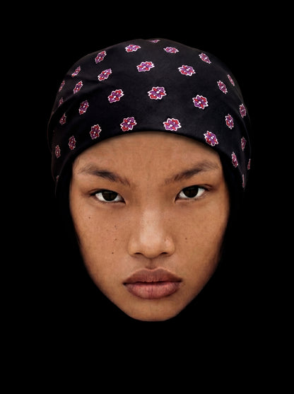 Bandana noire en coton avec médaillon, style élégant, portée comme accessoire de mode.