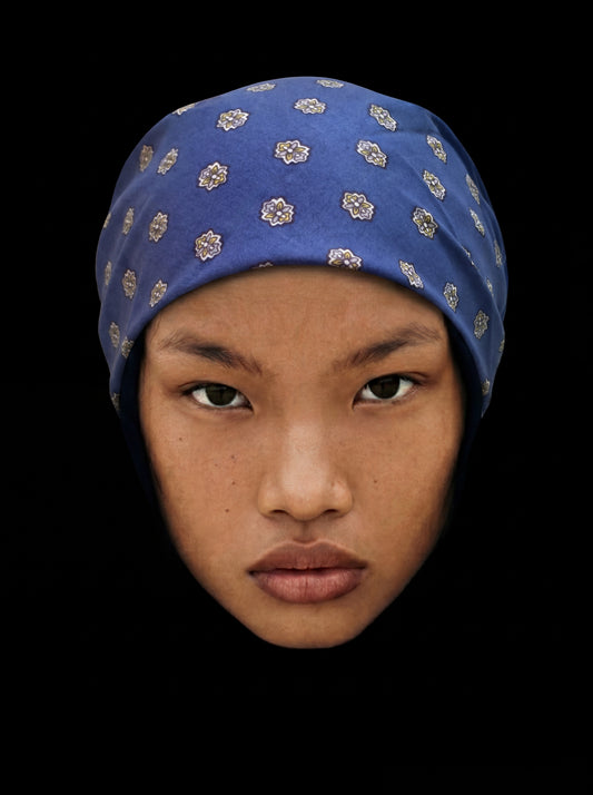 Bandana bleu avec médaillon en coton, accessoire de mode de style casual, porté avec élégance.