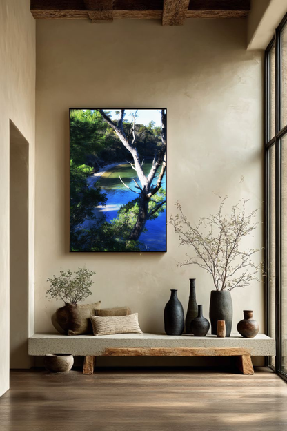 Tirage Coastal Refuge encadré en chêne, décoration murale nature avec crique sauvage et forêt littorale dans un intérieur lumineux.
