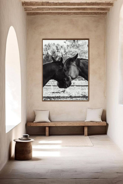 Photographie équestre en noir et blanc encadrée, accrochée sur un mur beige texturé dans un intérieur minimaliste.