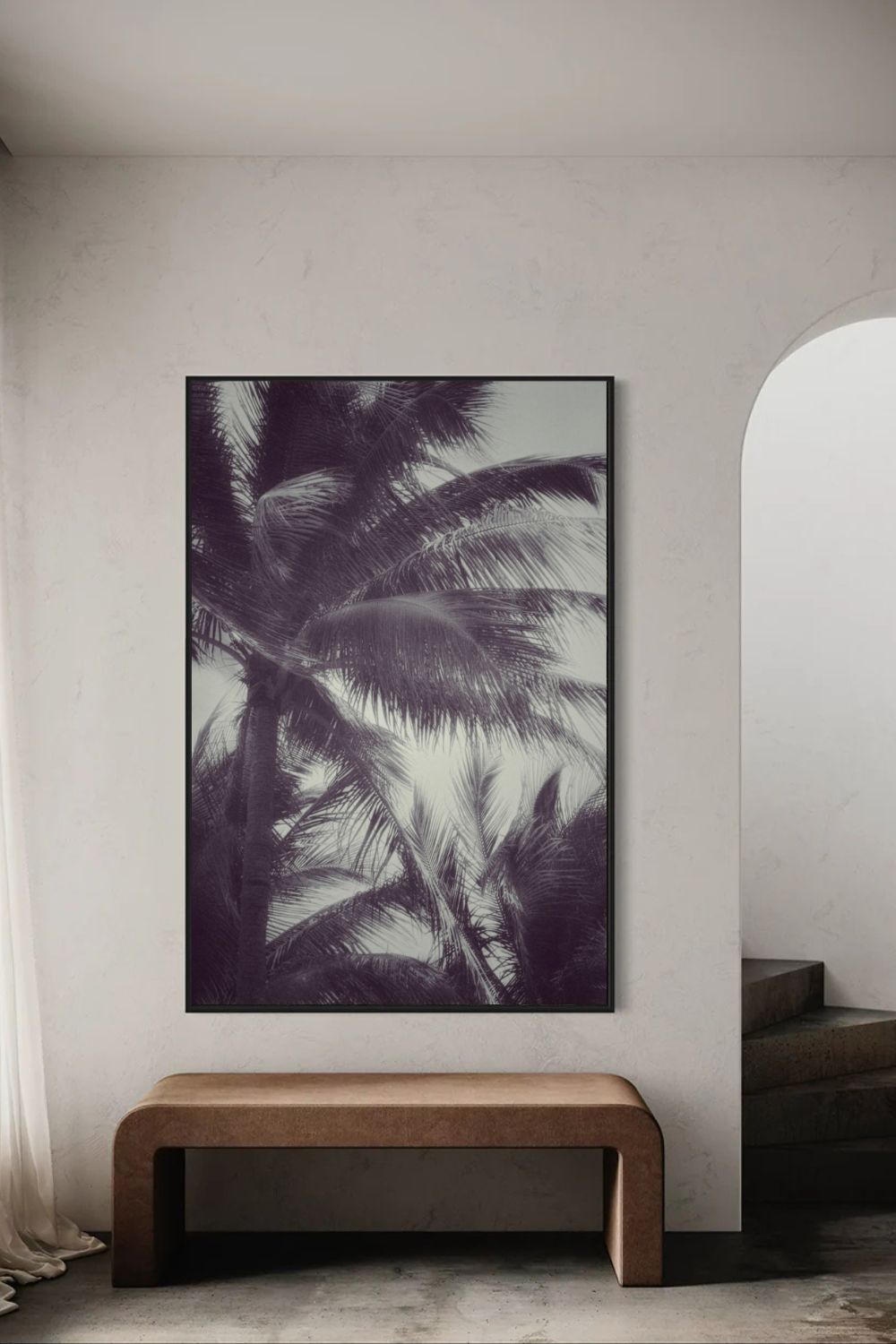Photographie fine art  Tropical Breath encadrée, feuilles de palmier en lumière douce, présentée dans un intérieur minimaliste avec arche et banc moderne.
