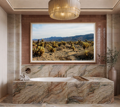 Photographie Fine Art de Joshua Tree encadrée dans un cadre en chêne, suspendue au‑dessus d’une baignoire dans une salle de bain élégante, apportant une touche naturelle et apaisante à la décoration intérieure.