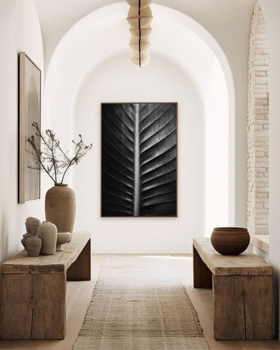 Photographie fine art “Sacred Art of Nature” de Maxime Guengant accrochée dans un hall d’entrée aux arches et décor naturel, montrant une feuille en gros plan aux nervures sculpturales.
