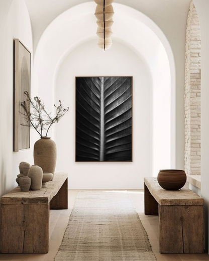 Photographie fine art “Sacred Art of Nature” de Maxime Guengant accrochée dans un hall d’entrée aux arches et décor naturel, montrant une feuille en gros plan aux nervures sculpturales.