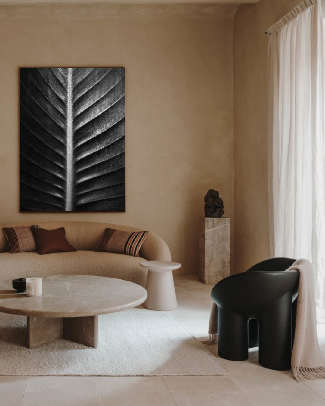 Tirage d’art “Sacred Art of Nature” de Maxime Guengant accroché dans un salon minimaliste beige, mettant en scène une feuille en noir et blanc aux nervures détaillées.